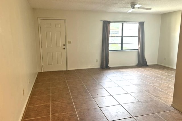 tiled spare room featuring ceiling fan and a textured ceiling