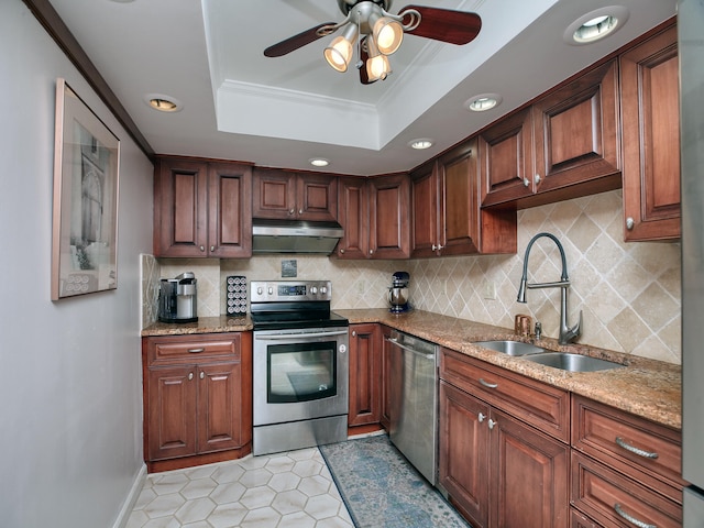 kitchen with light tile patterned floors, light stone counters, ceiling fan, appliances with stainless steel finishes, and a raised ceiling