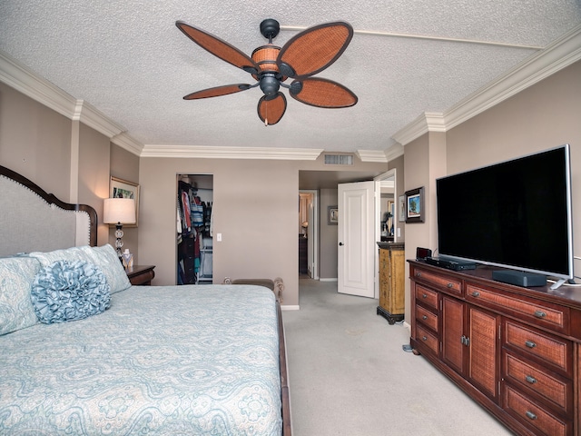 carpeted bedroom featuring a textured ceiling, crown molding, a closet, and ceiling fan