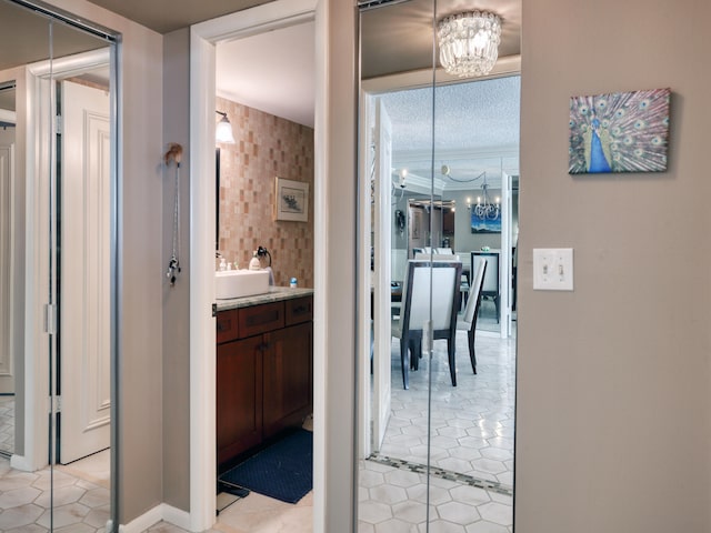 bathroom featuring a notable chandelier, vanity, a textured ceiling, and tile patterned flooring