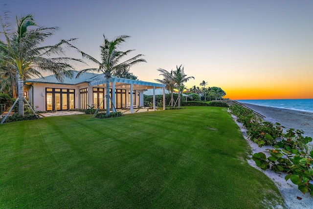 yard at dusk featuring a water view