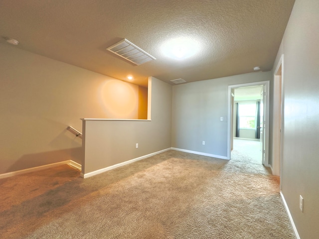 empty room with carpet floors and a textured ceiling