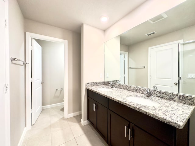 bathroom with double vanity and tile patterned flooring