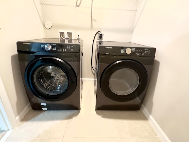 laundry room featuring light tile patterned flooring and washer and dryer