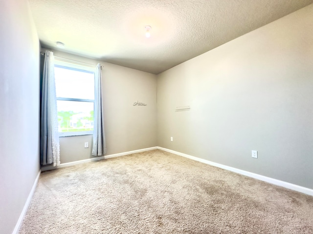 carpeted spare room with a textured ceiling