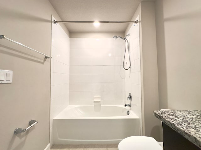 full bathroom featuring vanity, a textured ceiling, tiled shower / bath combo, and toilet