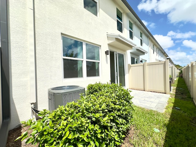 view of side of property with central air condition unit and a patio area