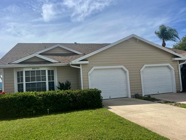 single story home featuring a front lawn and a garage