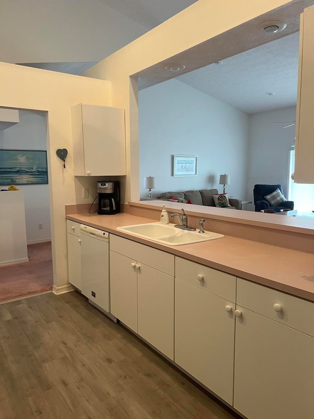 kitchen with white cabinetry, white dishwasher, sink, and carpet floors