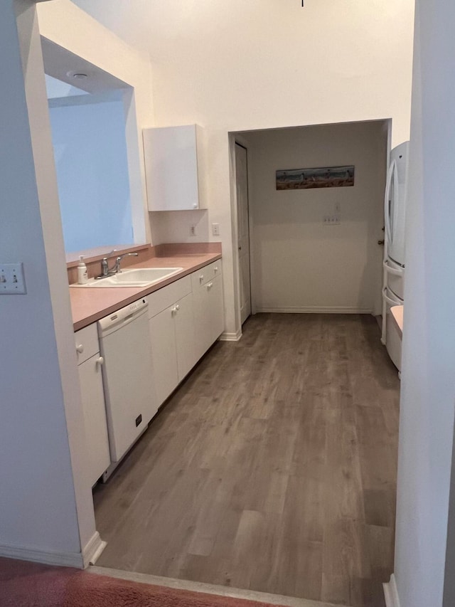 kitchen with light hardwood / wood-style flooring, white appliances, sink, and white cabinetry