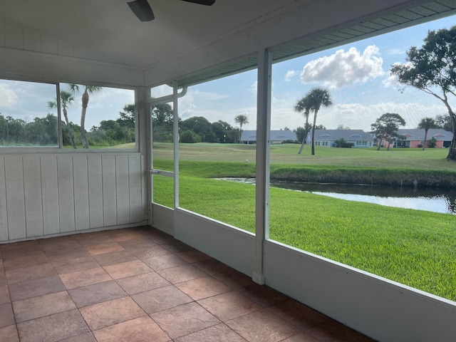 unfurnished sunroom featuring a water view, plenty of natural light, and ceiling fan