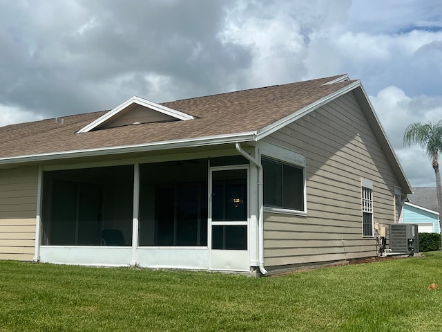 rear view of house featuring a sunroom and a yard