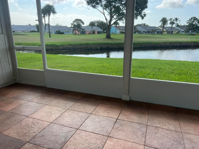 unfurnished sunroom with a water view