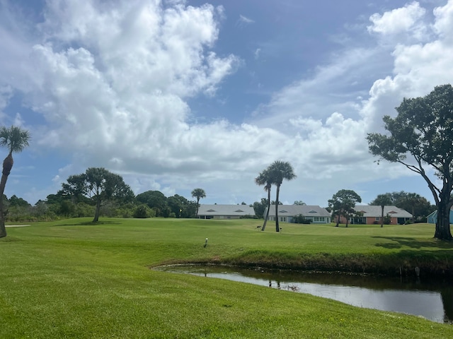 view of home's community with a water view and a yard