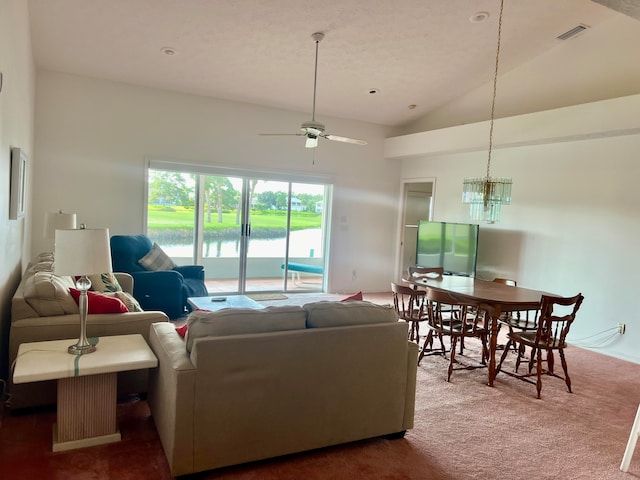 carpeted living room with high vaulted ceiling and ceiling fan with notable chandelier