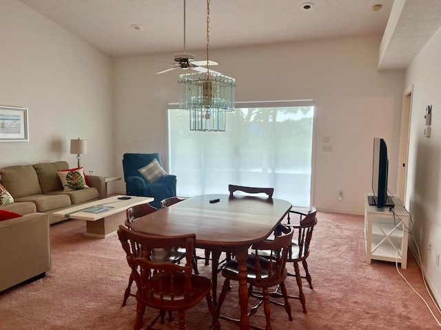 dining room with ceiling fan with notable chandelier and carpet