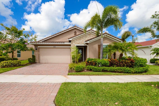 ranch-style home with an attached garage, stone siding, decorative driveway, stucco siding, and a front lawn