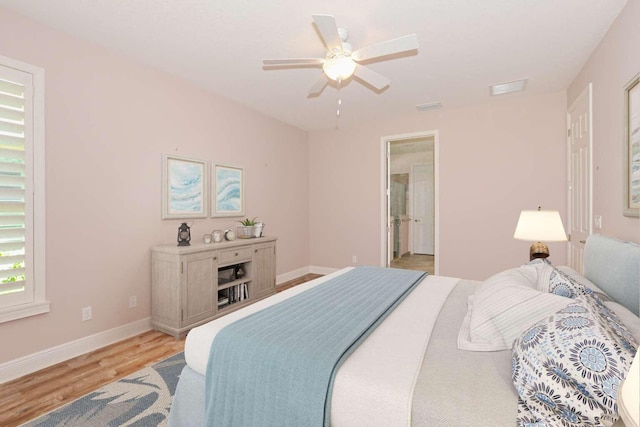 bedroom featuring ensuite bath, ceiling fan, and light wood-type flooring