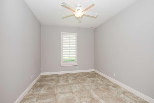 unfurnished room with ceiling fan and baseboards