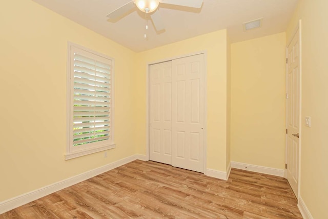 unfurnished bedroom with a closet, light wood-type flooring, and ceiling fan