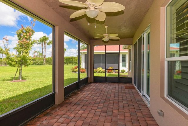 unfurnished sunroom featuring ceiling fan