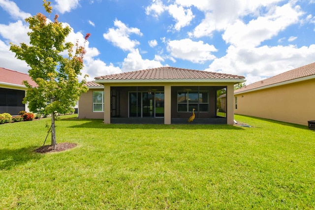 rear view of house with a sunroom and a lawn