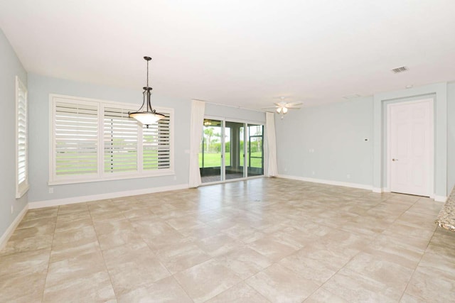 empty room featuring baseboards, visible vents, and a ceiling fan