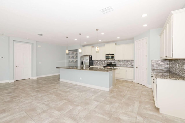 kitchen with light tile patterned flooring, tasteful backsplash, white cabinets, a kitchen island with sink, and appliances with stainless steel finishes