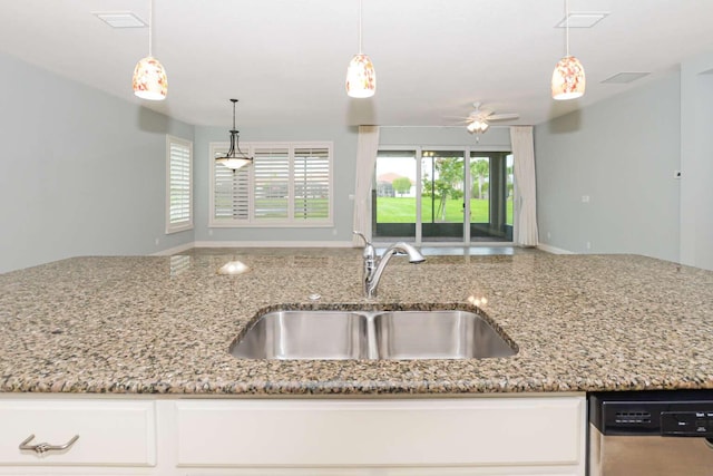 kitchen featuring sink, pendant lighting, light stone counters, dishwasher, and ceiling fan