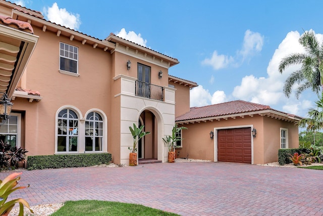 mediterranean / spanish house with a garage and a balcony