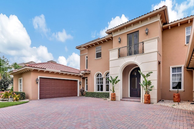 mediterranean / spanish-style home featuring a balcony and a garage