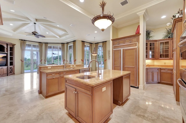 kitchen featuring a center island with sink, crown molding, decorative light fixtures, sink, and ceiling fan