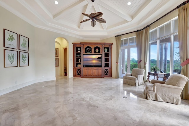 living room with wood ceiling, ornamental molding, ceiling fan, beam ceiling, and a high ceiling