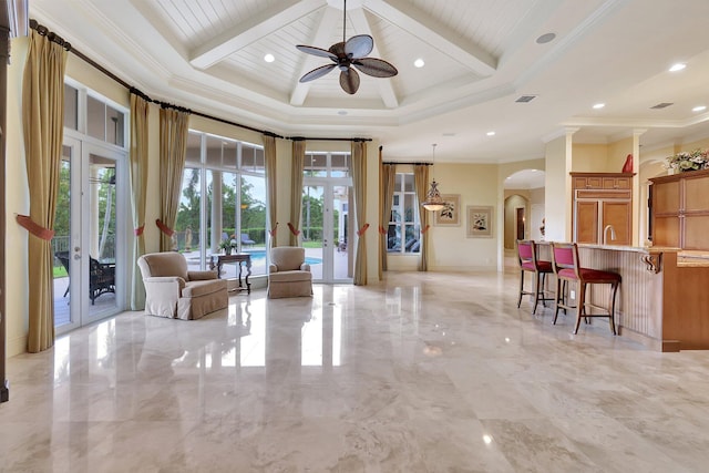 sitting room with french doors, beamed ceiling, ceiling fan, and crown molding