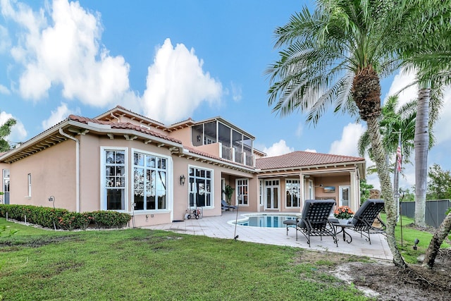 back of property with a patio, a sunroom, and a yard