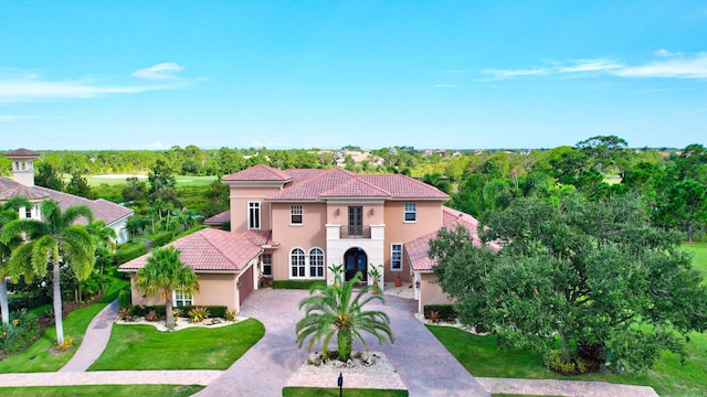 mediterranean / spanish-style home with a balcony and a front yard