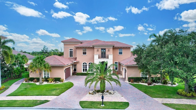 mediterranean / spanish-style house featuring a front lawn and a balcony