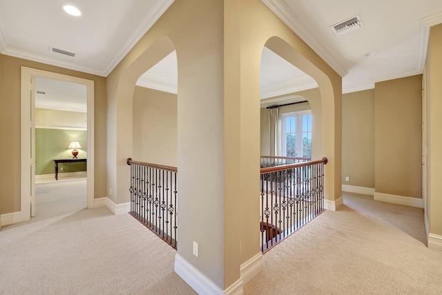 hall with light colored carpet and crown molding