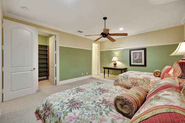 carpeted bedroom with ceiling fan, a spacious closet, and ornamental molding