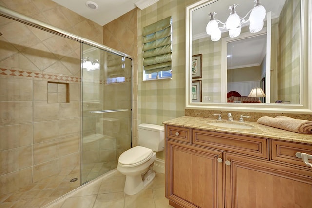 bathroom with tile patterned floors, toilet, a shower with door, vanity, and crown molding