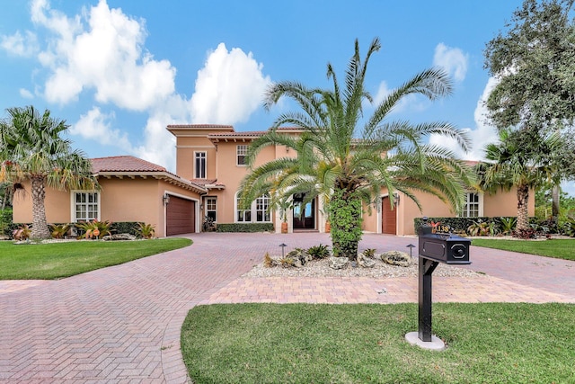 mediterranean / spanish house with a garage and a front lawn