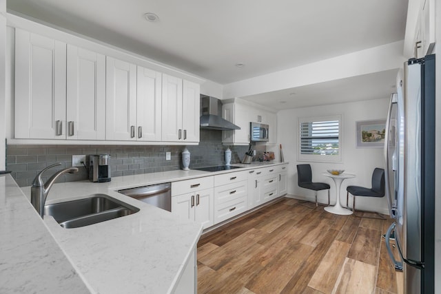 kitchen featuring white cabinetry, appliances with stainless steel finishes, sink, and wall chimney exhaust hood