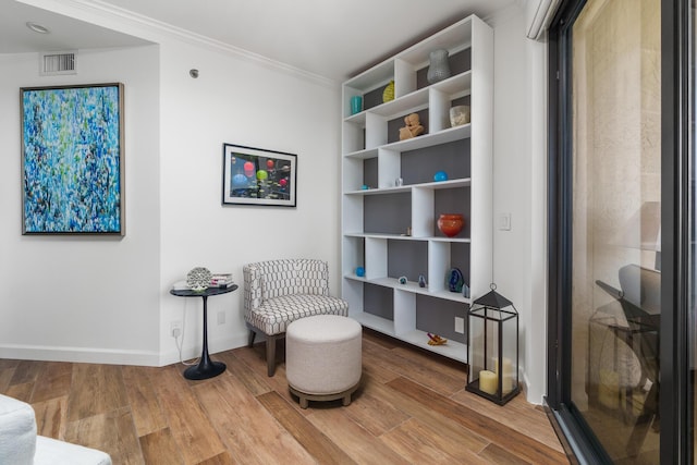 sitting room featuring crown molding and hardwood / wood-style flooring