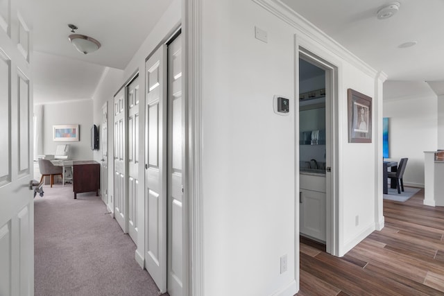 hall with ornamental molding and dark wood-type flooring