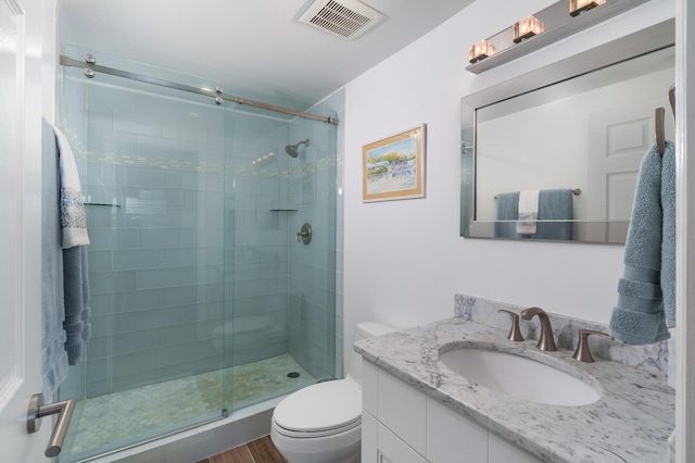 bathroom with vanity, a shower with shower door, wood-type flooring, and toilet