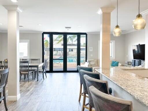 interior space with light stone counters, a wall of windows, decorative light fixtures, and a wealth of natural light