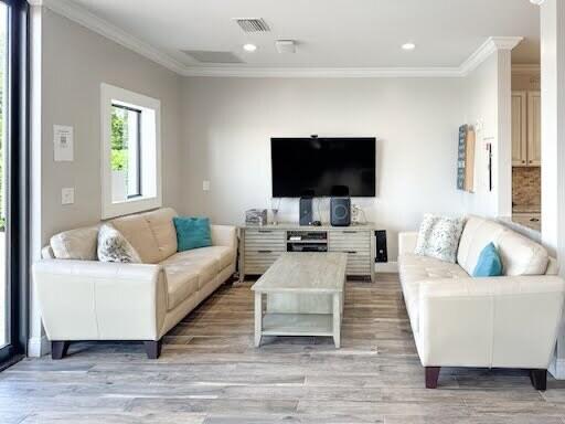 living room featuring ornamental molding and light wood-type flooring