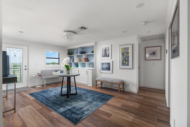 interior space with hardwood / wood-style flooring, built in features, and a chandelier