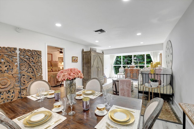 dining room with ceiling fan, wood-type flooring, and a barn door