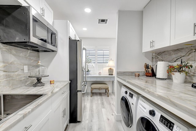 laundry area with washer and dryer, sink, and light wood-type flooring